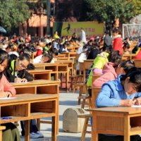 Milhares de Estudantes Fazem Exame ao Ar Livre, Sob a Supervisão de Professores com Binóculos